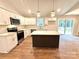 Bright kitchen features white cabinets, stainless appliances, quartz countertops, and center island with wood laminate flooring at 2330 Neill Rd, Lancaster, SC 29720