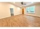 Bright, spacious living room featuring light wood-look floors, a modern ceiling fan, and a traditional wood door at 2330 Neill Rd, Lancaster, SC 29720
