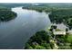 Stunning aerial view of a lakefront home surrounded by lush greenery and a vast expanse of water at 24756 Strand Dr, Albemarle, NC 28001