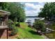 Gorgeous lake view from the backyard with lush lawn, mature trees, and a private dock at 24756 Strand Dr, Albemarle, NC 28001