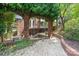 Charming backyard patio with beautiful brick arches, a cozy dining area, and lush greenery at 24756 Strand Dr, Albemarle, NC 28001