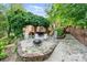 Fire pit and brick patio with rocking chairs and mature trees at 24756 Strand Dr, Albemarle, NC 28001