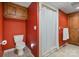 Bathroom featuring a toilet and shower with red walls and tiled floors at 24756 Strand Dr, Albemarle, NC 28001