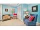Stylish bedroom featuring blue walls, a shuttered window, a dresser, and a comfortable armchair at 24756 Strand Dr, Albemarle, NC 28001