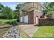 Large brick boathouse featuring two garage doors, an upper deck, and easy lake access at 24756 Strand Dr, Albemarle, NC 28001