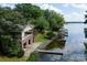 Waterfront home featuring a private dock with covered boat slip and grassy lawn at 24756 Strand Dr, Albemarle, NC 28001