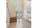 Bright and airy foyer featuring tiled floors, a staircase, double doors, and natural light from large windows at 24756 Strand Dr, Albemarle, NC 28001
