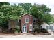 Charming front exterior showcasing a brick facade, arched windows, landscaped garden beds, and a welcoming entrance at 24756 Strand Dr, Albemarle, NC 28001