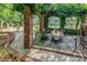 Inviting patio with brick pergola, dining table, and picturesque lake views at 24756 Strand Dr, Albemarle, NC 28001