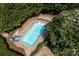 Aerial view of a refreshing in-ground pool surrounded by lush greenery, lounge chairs, and beautiful landscaping at 24756 Strand Dr, Albemarle, NC 28001
