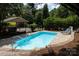 Refreshing outdoor pool with lounge chairs, surrounded by lush greenery and a fence at 24756 Strand Dr, Albemarle, NC 28001
