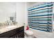 Bathroom features a granite countertop, vanity, toilet and a shower/tub combo with a colorful striped shower curtain at 2577 Shoal Park Rd, Concord, NC 28027