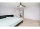 Light lavender bedroom with ceiling fan, bed, and doorway views into hallway at 2577 Shoal Park Rd, Concord, NC 28027