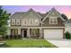 Charming two-story home with covered front porch, manicured lawn and attached two-car garage at 2577 Shoal Park Rd, Concord, NC 28027
