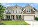 Charming two-story home with a well-maintained lawn, covered porch, and attached two-car garage at 2577 Shoal Park Rd, Concord, NC 28027
