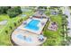 Aerial view of a community pool, kiddie pool, playground, and tennis courts, all surrounded by lush landscaping at 2577 Shoal Park Rd, Concord, NC 28027