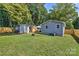 Private backyard with a shed, a fire pit, a deck, and lush green grass at 3020 Stancill Pl, Charlotte, NC 28205