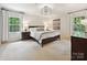 Bright bedroom with natural light, a comfortable king-size bed, and stylish decor and elegant chandelier at 327 Whitestone Rd, Charlotte, NC 28270