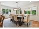 Dining room features a rustic wood table, upholstered chairs, modern light fixture and ample windows at 327 Whitestone Rd, Charlotte, NC 28270
