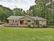 Inviting brick home with a well-manicured lawn, beautiful shrubs, and mature trees at 327 Whitestone Rd, Charlotte, NC 28270