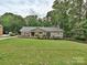 A charming home with a beautiful lawn, landscaping, and mature trees at 327 Whitestone Rd, Charlotte, NC 28270