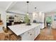 Bright open concept kitchen with an island and seating, next to a living room with fireplace at 327 Whitestone Rd, Charlotte, NC 28270