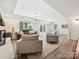 Bright living room features hardwood floors, neutral paint, and abundant natural light from large windows and patio doors at 327 Whitestone Rd, Charlotte, NC 28270