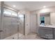 Bathroom with a tiled shower, glass door, and neutral-colored vanity with lots of natural light at 334 Kennerly Center Dr, Mooresville, NC 28115