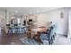 Bright dining area featuring a wooden table, bench, and gray chairs, plus kitchen access with barstool seating at 334 Kennerly Center Dr, Mooresville, NC 28115