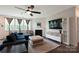Relaxing living room with a dark blue sofa, fireplace, large windows, and a ceiling fan at 334 Kennerly Center Dr, Mooresville, NC 28115