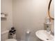 Compact powder room featuring a pedestal sink, decorative mirror, and modern toilet at 334 Kennerly Center Dr, Mooresville, NC 28115