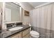 Well-lit bathroom featuring a large mirror, granite countertops, a single sink, and a bathtub/shower combo at 3980 English Oak Dr, Lincolnton, NC 28092