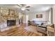 Cozy living room featuring a stone fireplace, hardwood floors, and comfortable seating, creating a warm ambiance at 3980 English Oak Dr, Lincolnton, NC 28092