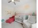 Bright Bedroom with desert theme mural, white crib, red chair, and neutral rocker, perfect for a growing Gathering at 416 Linestowe Dr, Belmont, NC 28012