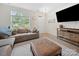 Bright and airy living room featuring a large window, plush sofa, and entertainment center at 416 Linestowe Dr, Belmont, NC 28012