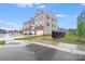 View of the exterior of gray townhomes with driveways and lawns on a sunny day at 416 Moondance Dr # 121, Gastonia, NC 28054