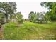 Expansive backyard featuring lush lawn, mature trees, and a garden shed at 4320 Atkinson Way, Monroe, NC 28110