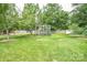 Large backyard with healthy lawn, mature trees, garden cage, and wood fence at 4320 Atkinson Way, Monroe, NC 28110