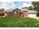 Charming brick home featuring red shutters, a well-manicured lawn, and a two-car garage at 4320 Atkinson Way, Monroe, NC 28110