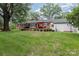 Expansive backyard featuring a brick patio with outdoor seating, lush green grass, and mature trees at 441 Crestside Se Dr, Concord, NC 28025