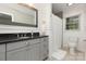 Modern bathroom features gray cabinets, dark countertops, wainscoting, and bright natural light at 441 Crestside Se Dr, Concord, NC 28025