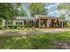Classic brick home with a brick walkway, manicured bushes, black shutters, and a welcoming front porch at 441 Crestside Se Dr, Concord, NC 28025