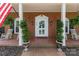 Charming front porch with brick flooring, classic white columns, hanging ferns, and rocking chairs at 441 Crestside Se Dr, Concord, NC 28025