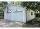Two car garage with white exterior, American flag, and well-maintained landscaping in a quiet setting at 441 Crestside Se Dr, Concord, NC 28025