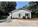Detached garage with white siding, black shutters, and a well-maintained yard surrounded by trees at 441 Crestside Se Dr, Concord, NC 28025