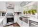 Modern kitchen featuring stainless steel sink, white cabinets, stainless steel oven, and a window with plants at 441 Crestside Se Dr, Concord, NC 28025