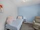 A cozy bedroom features light blue walls, a bed, and a small white nightstand next to a recliner at 4607 Silk Tree Ln, Rock Hill, SC 29732