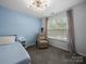 A comfortable bedroom with soft blue walls, a recliner chair, and bright natural light at 4607 Silk Tree Ln, Rock Hill, SC 29732