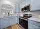 Modern kitchen featuring stainless steel appliances, sleek countertops, and chic blue cabinets at 4607 Silk Tree Ln, Rock Hill, SC 29732