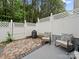 Private patio area with brick flooring, rocking chairs, grill, and white privacy fence at 4607 Silk Tree Ln, Rock Hill, SC 29732